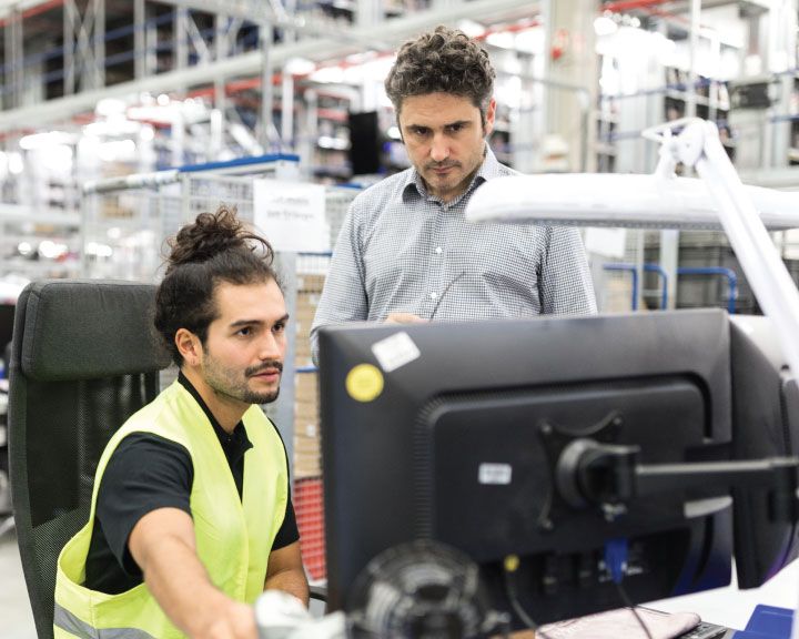 Two workers monitoring data in their TMS. 