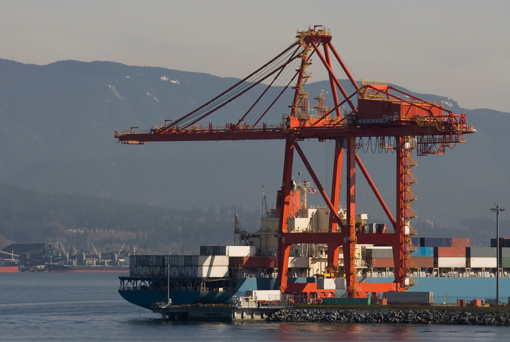 Cargo ship being unloaded in port. 